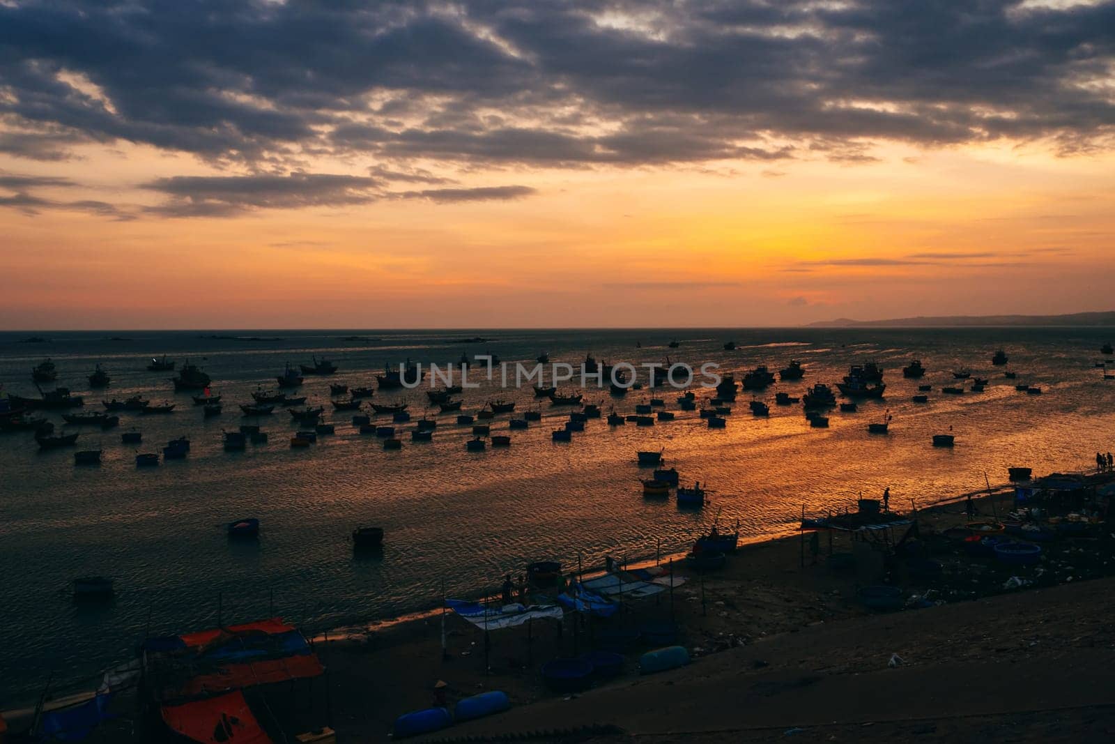 traditional Vietnamese fishing boats on the sea in the background of orange sunset