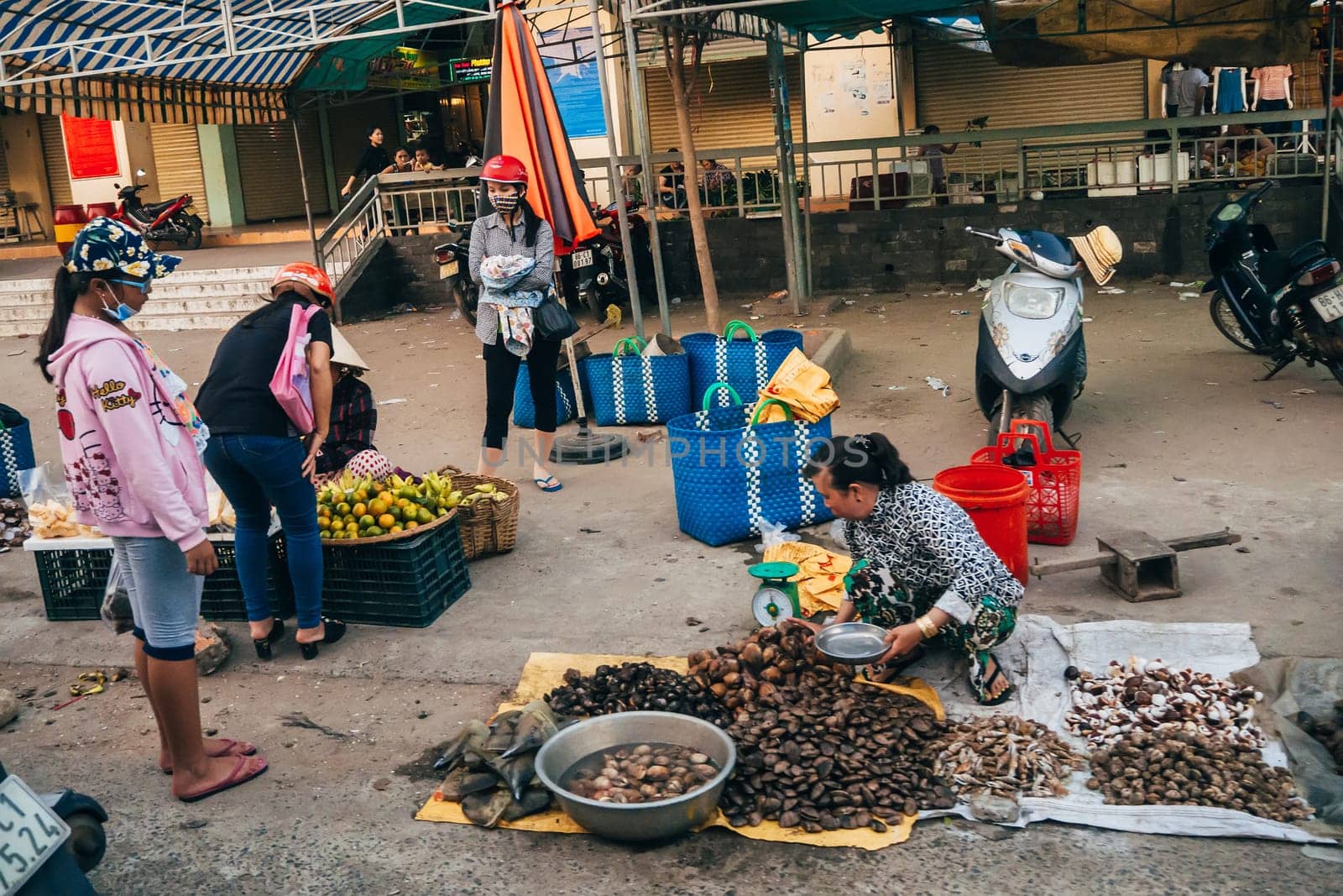 MUI NE, VIETNAM - CIRCA MARCH 2017: A woman sells sea shellfish on the street on the sidewalk