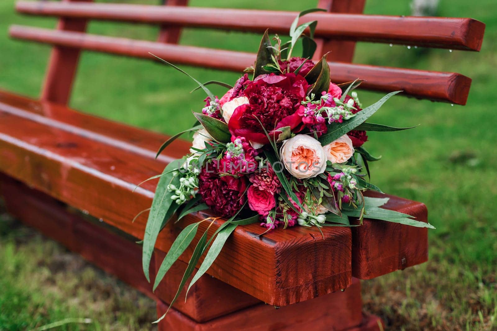 beautiful wedding bouquet with red peonies and green leaves