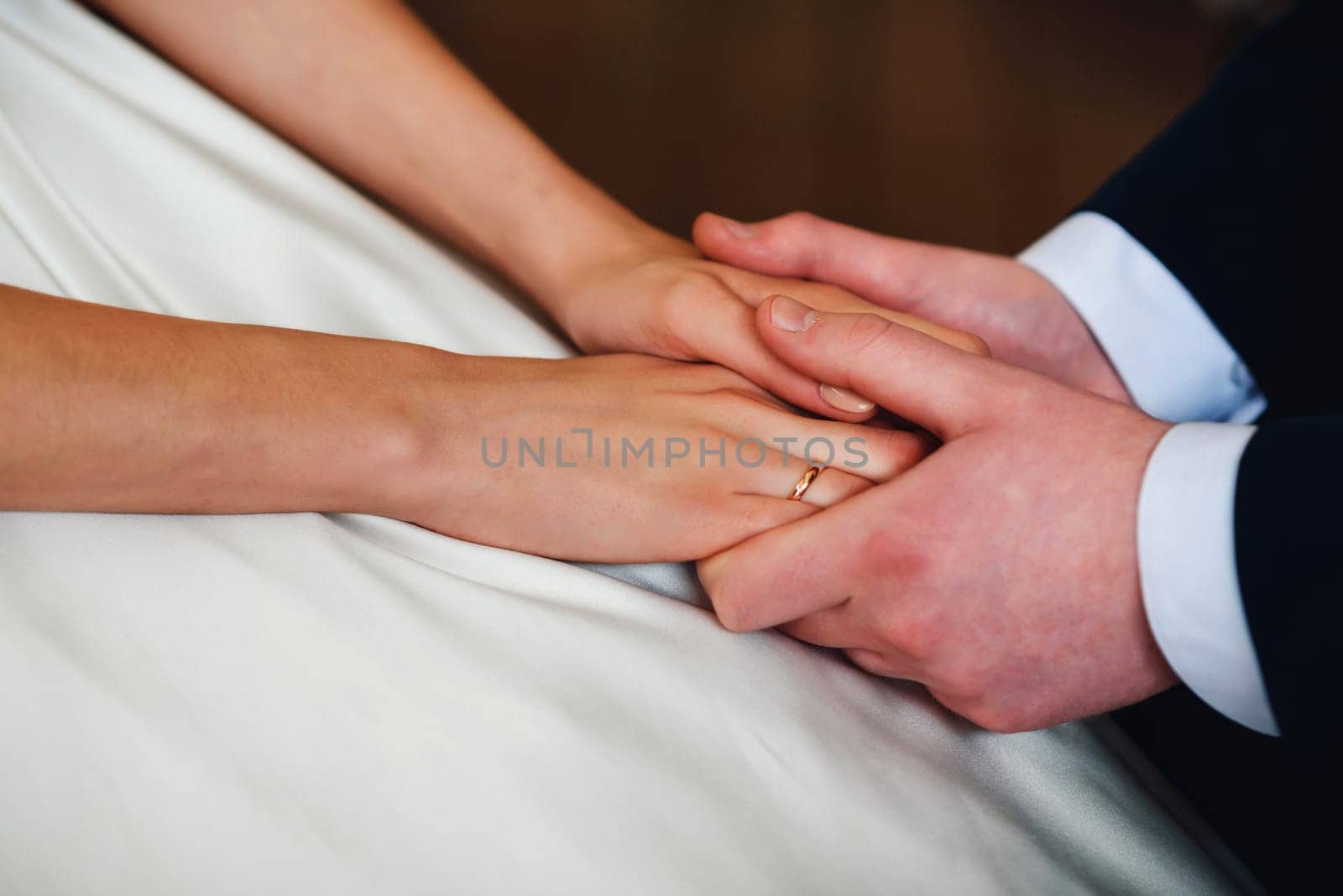 bride and groom hold hands together. Symbolizes love, romance and happiness