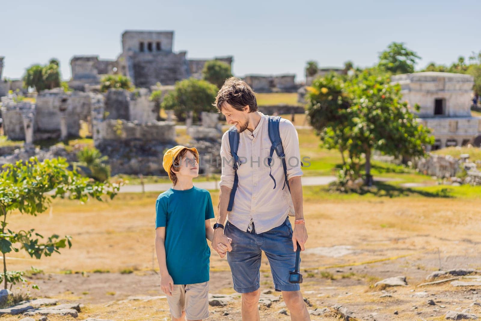 Father and son tourists enjoying the view Pre-Columbian Mayan walled city of Tulum, Quintana Roo, Mexico, North America, Tulum, Mexico. El Castillo - castle the Mayan city of Tulum main temple by galitskaya