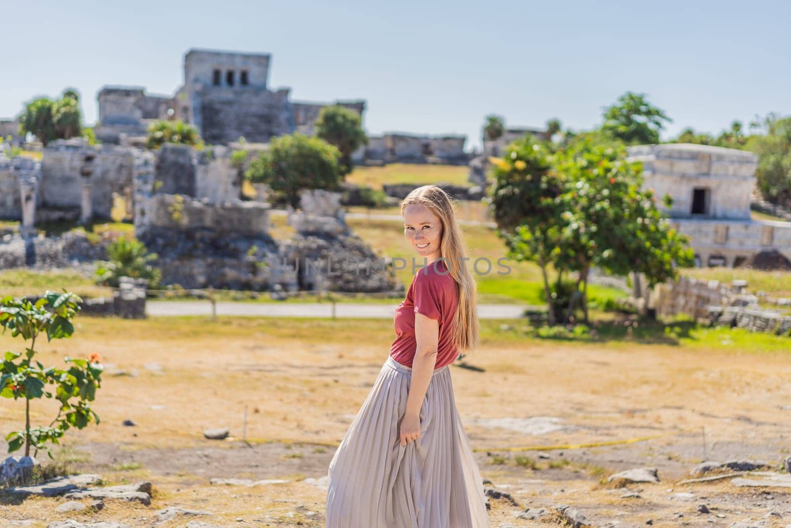 Woman tourist enjoying the view Pre-Columbian Mayan walled city of Tulum, Quintana Roo, Mexico, North America, Tulum, Mexico. El Castillo - castle the Mayan city of Tulum main temple by galitskaya