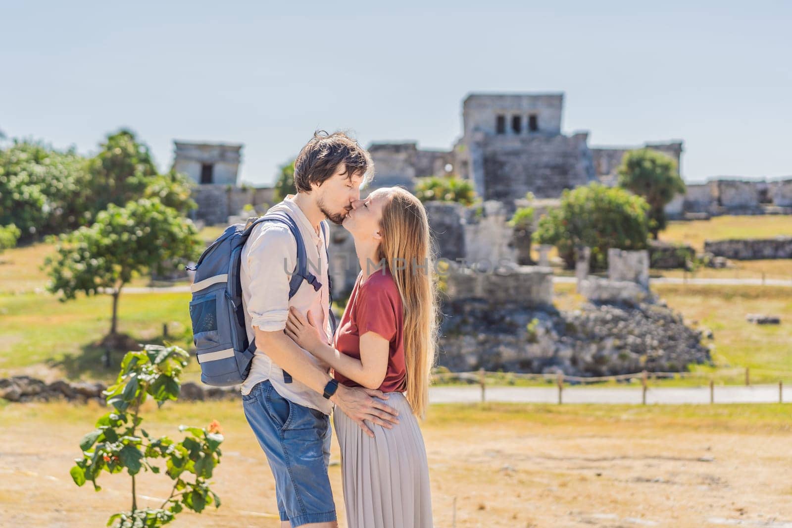 Couple man and woman tourists enjoying the view Pre-Columbian Mayan walled city of Tulum, Quintana Roo, Mexico, North America, Tulum, Mexico. El Castillo - castle the Mayan city of Tulum main temple.