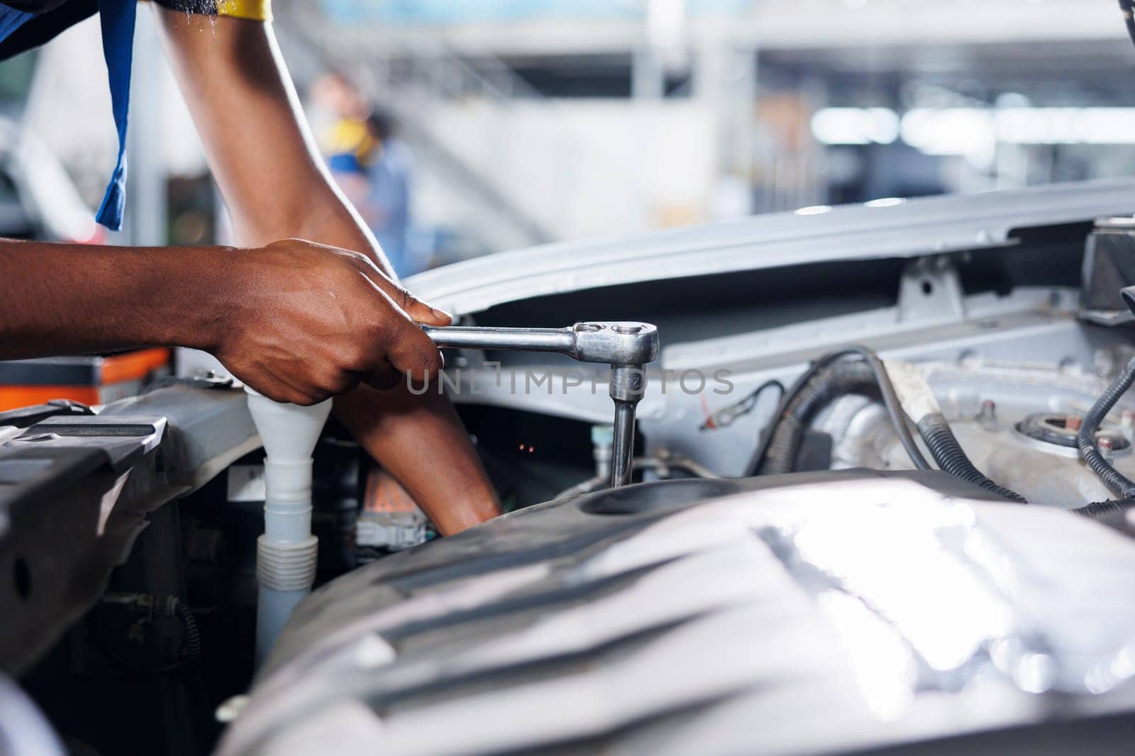 Engineer expertly examines car compressor belt using advanced mechanical tools, ensuring optimal automotive performance and safety. Skilled garage employee conducts annual vehicle checkup, close up