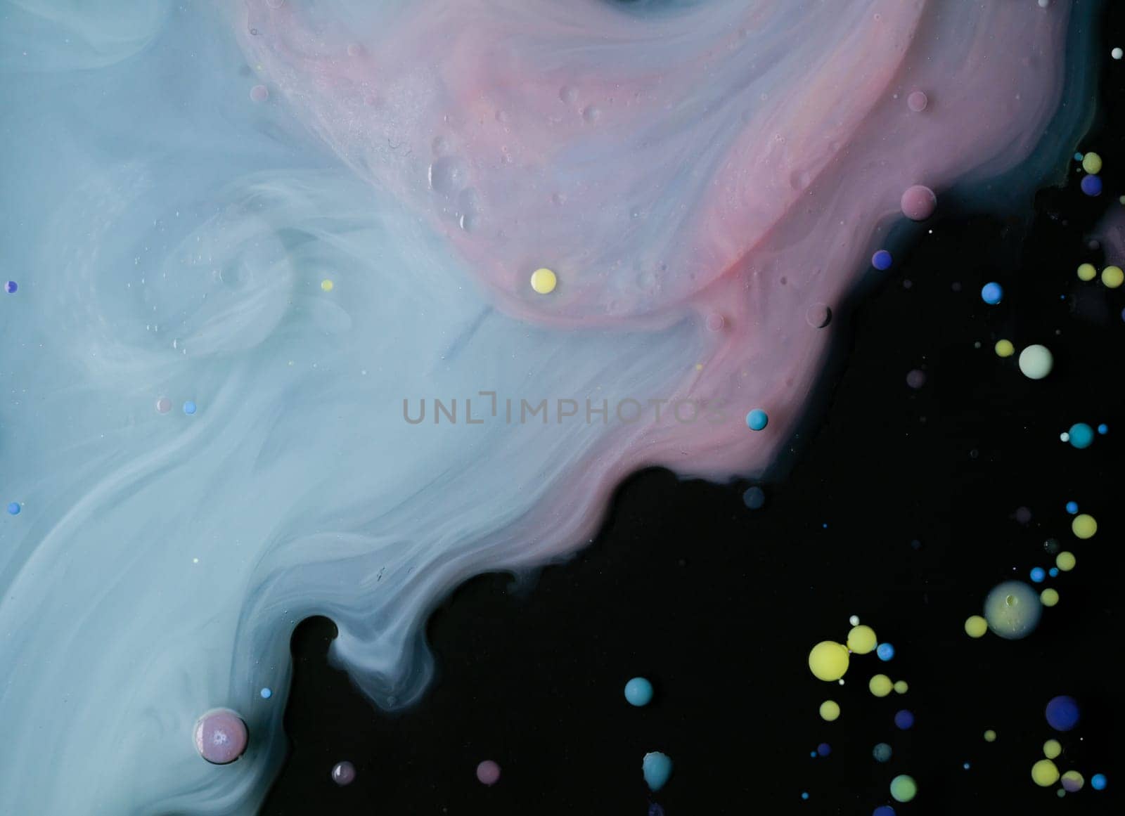 A myriad of oil droplets intermingling with water, creating a mesmerizing effect reminiscent of a galaxy.