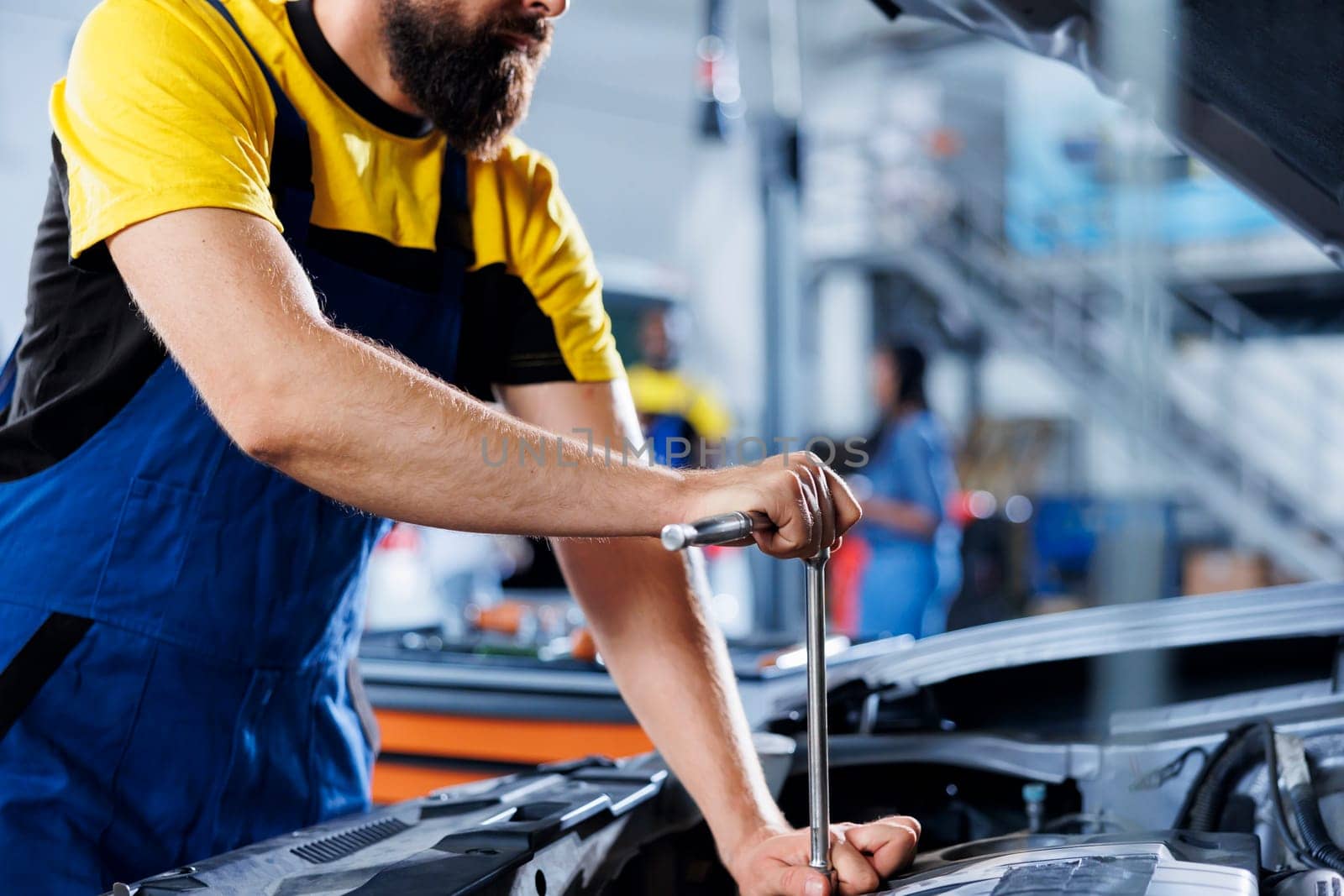 Garage employee replaces car brakes by DCStudio