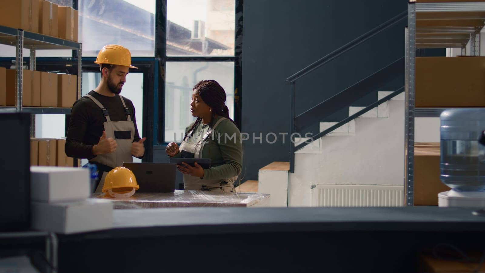 Dolly out shot of employees doing warehouse inventory analysis, keeping quality standards high. Experts in storage room checking labels on stockpiled merchandise, crosschecking delivery info