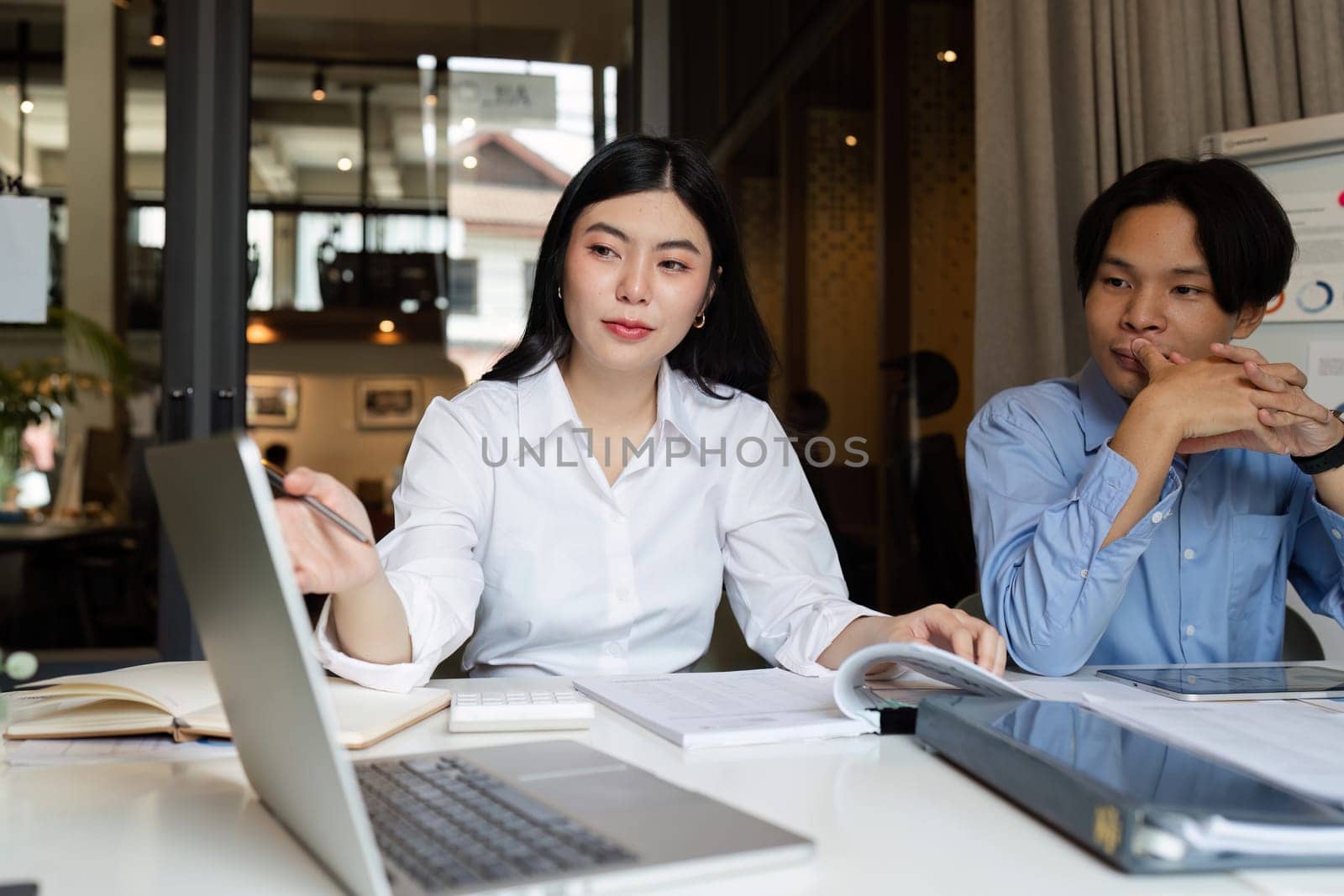 businesswoman having a discussion with her colleagues in a boardroom. Group of happy businesspeople sharing ideas during a meeting.