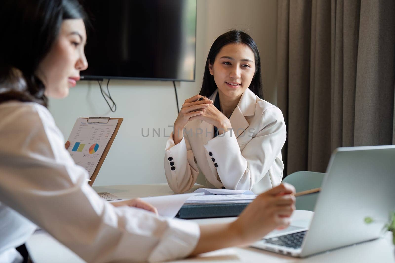 businesswoman having a discussion with her colleagues in a boardroom. Group of happy businesspeople sharing ideas during a meeting.