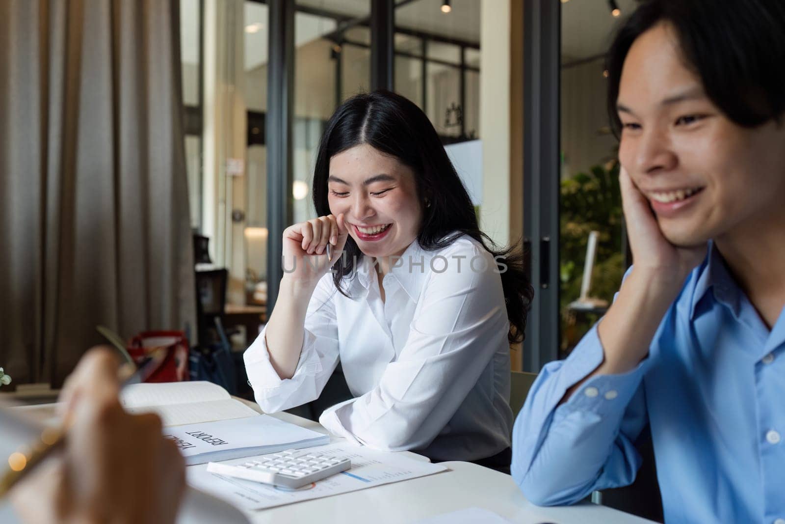 businesswoman having a discussion with her colleagues in a boardroom. Group of happy businesspeople sharing ideas during a meeting.