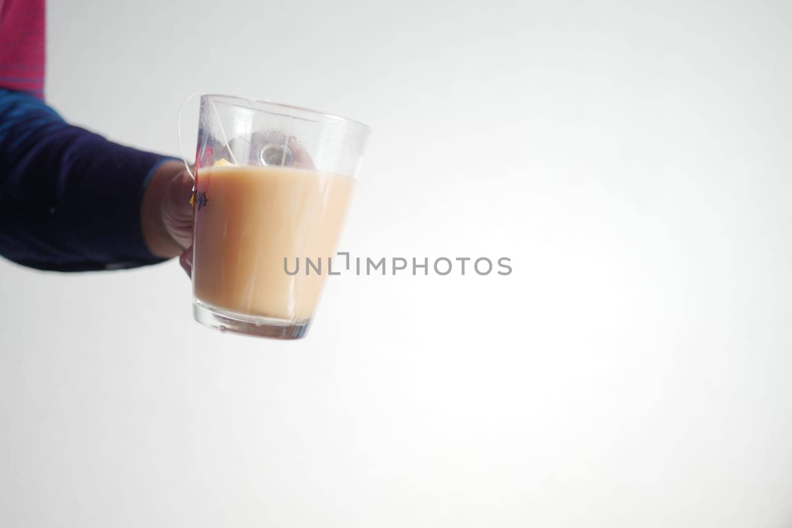 hand holding a glass of milk tea by towfiq007