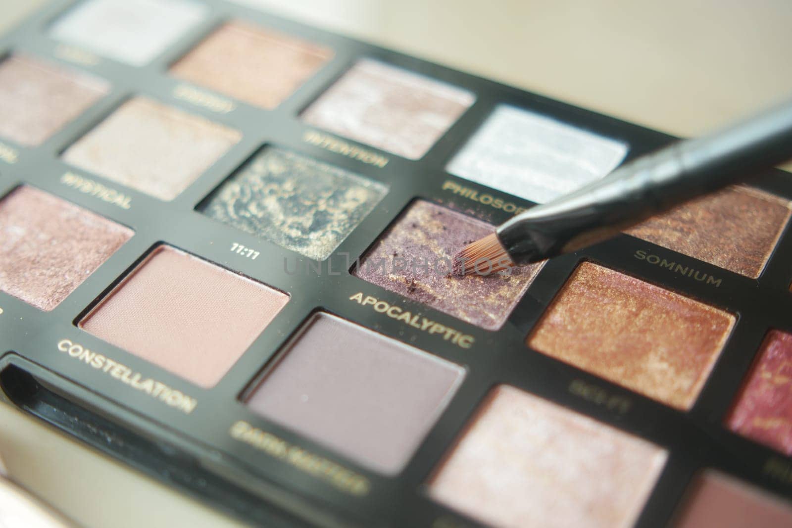 A palette with eye shadows and a makeup brush