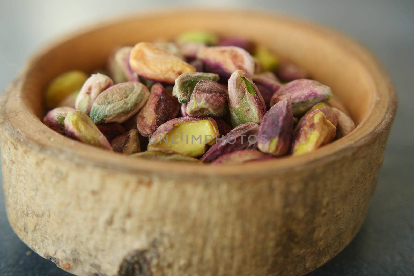 Wooden bowl filled with pistachios, a natural and nutritious superfood.