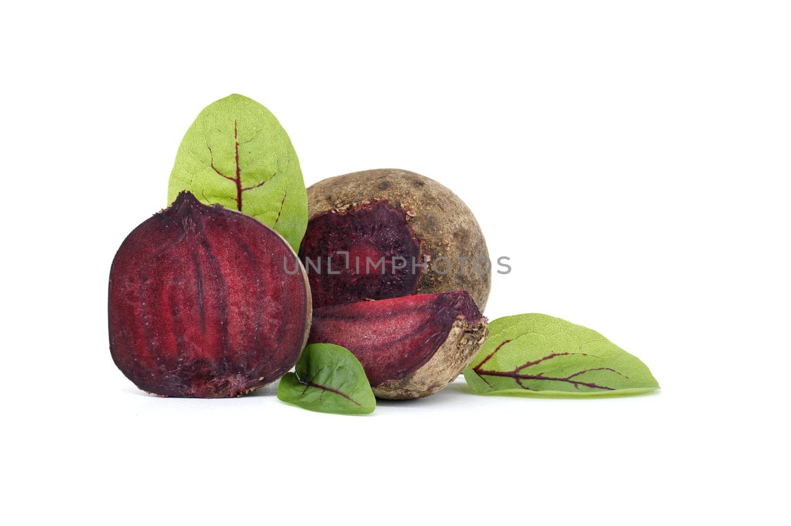 Collection of whole beetroot arranged next to slices of beetroot vegetables with their green leaves still attached isolated on a white background