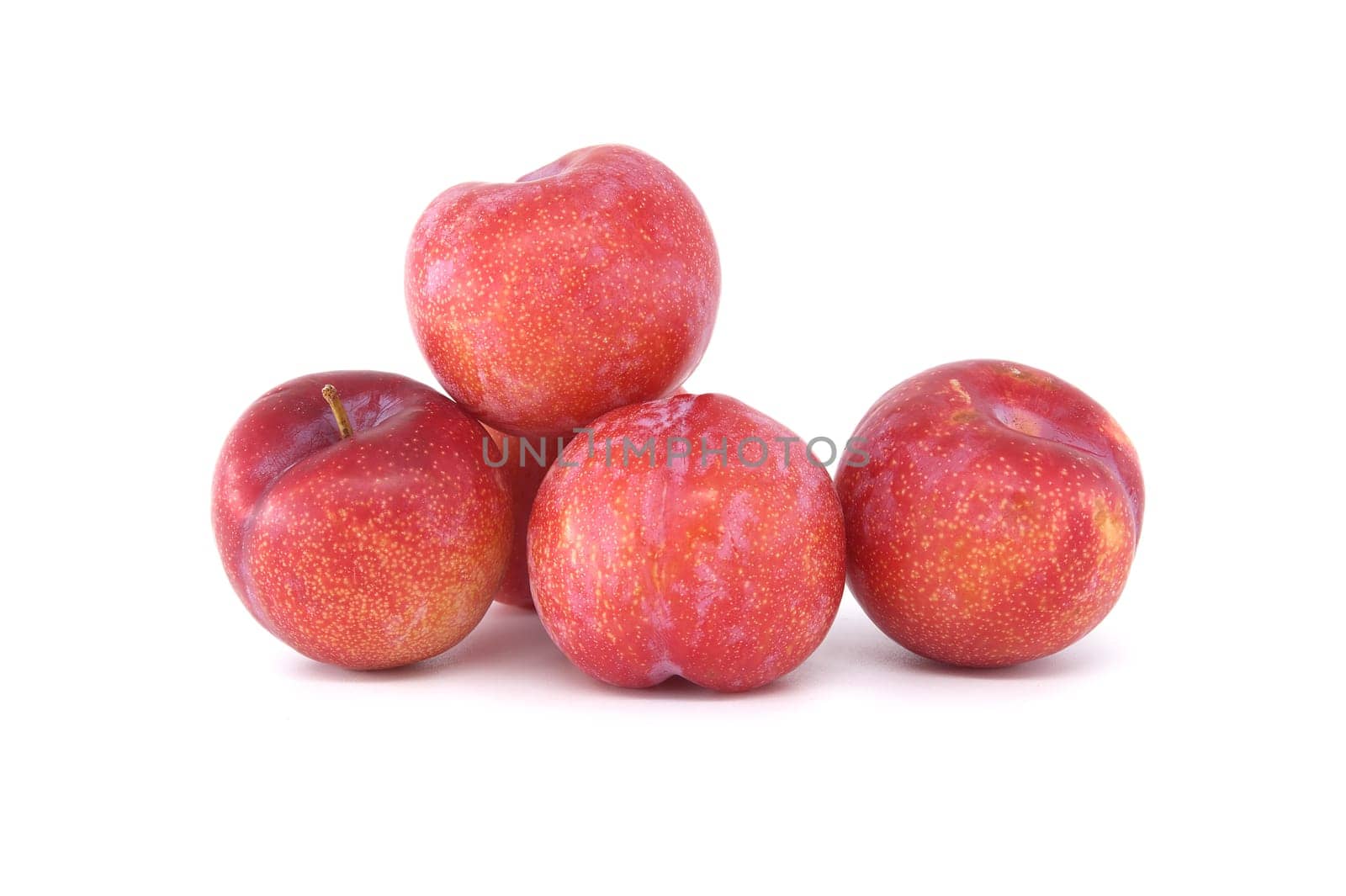 Four crimson plums arranged against a white background