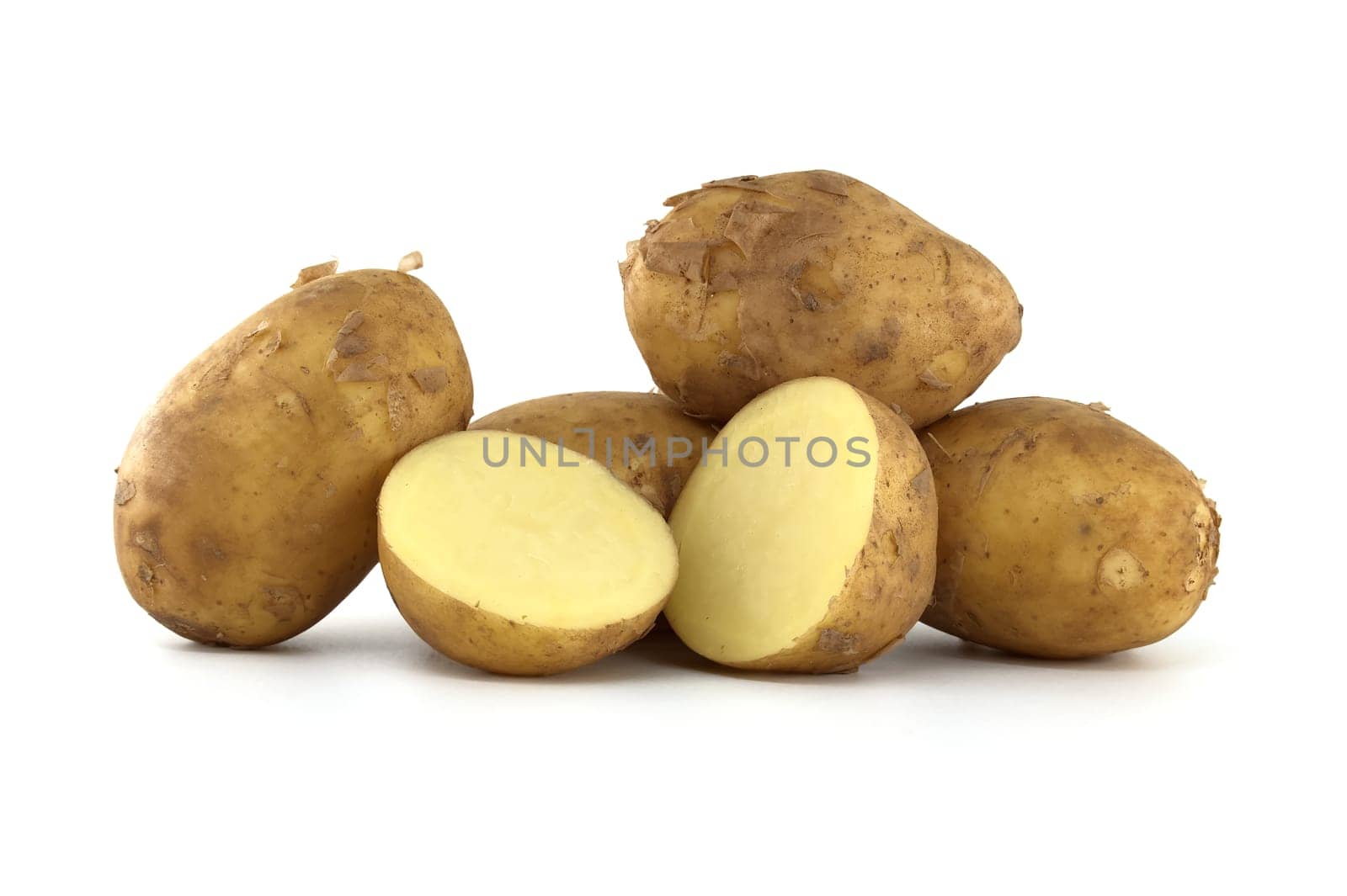 Group of fresh early potatoes, with a light brown skin and dark brown spots isolated on a white background, one potato bisected displaying its yellow interior