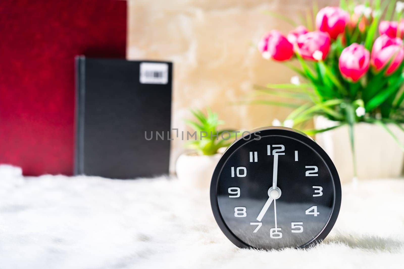 Alarm clock and book with pink flower  by stoonn