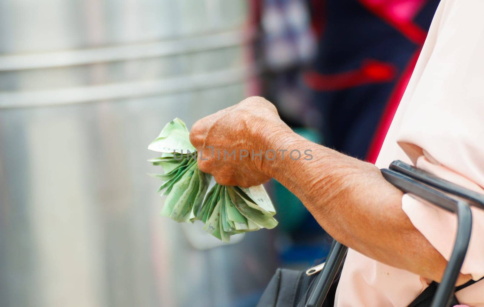 An elderly woman's hands holding money  by stoonn