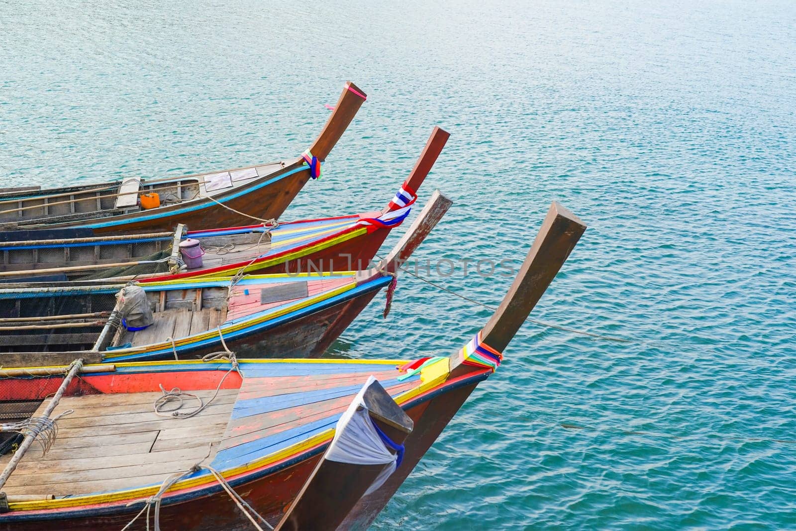 Close up Small fishing boats anchored in the sea by stoonn