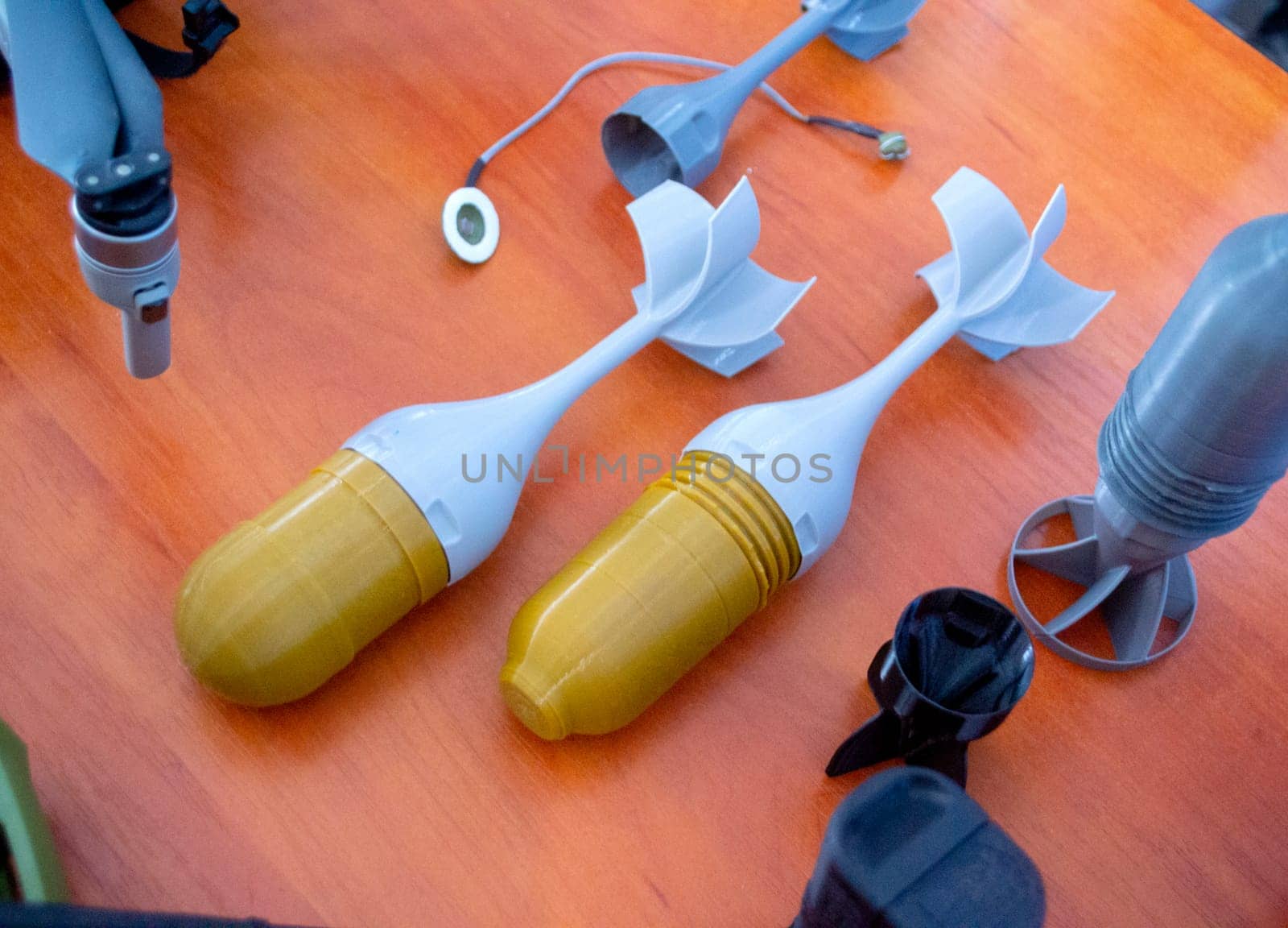 Prototype model of rocket bomb tip printed on 3D printer. Small models of tail fins, tail cone printed on 3D printer from molten plastic. Military weapons. New modern innovation printing technology