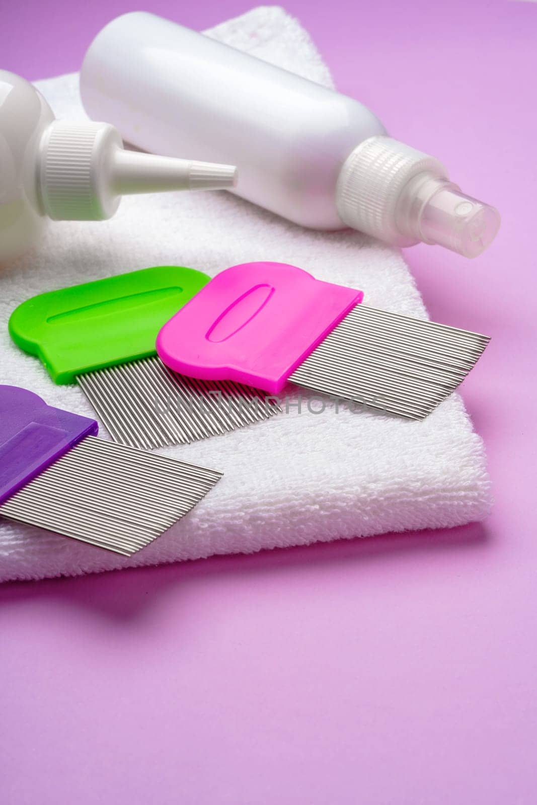 Anti lice combs and towel on pink background studio shot