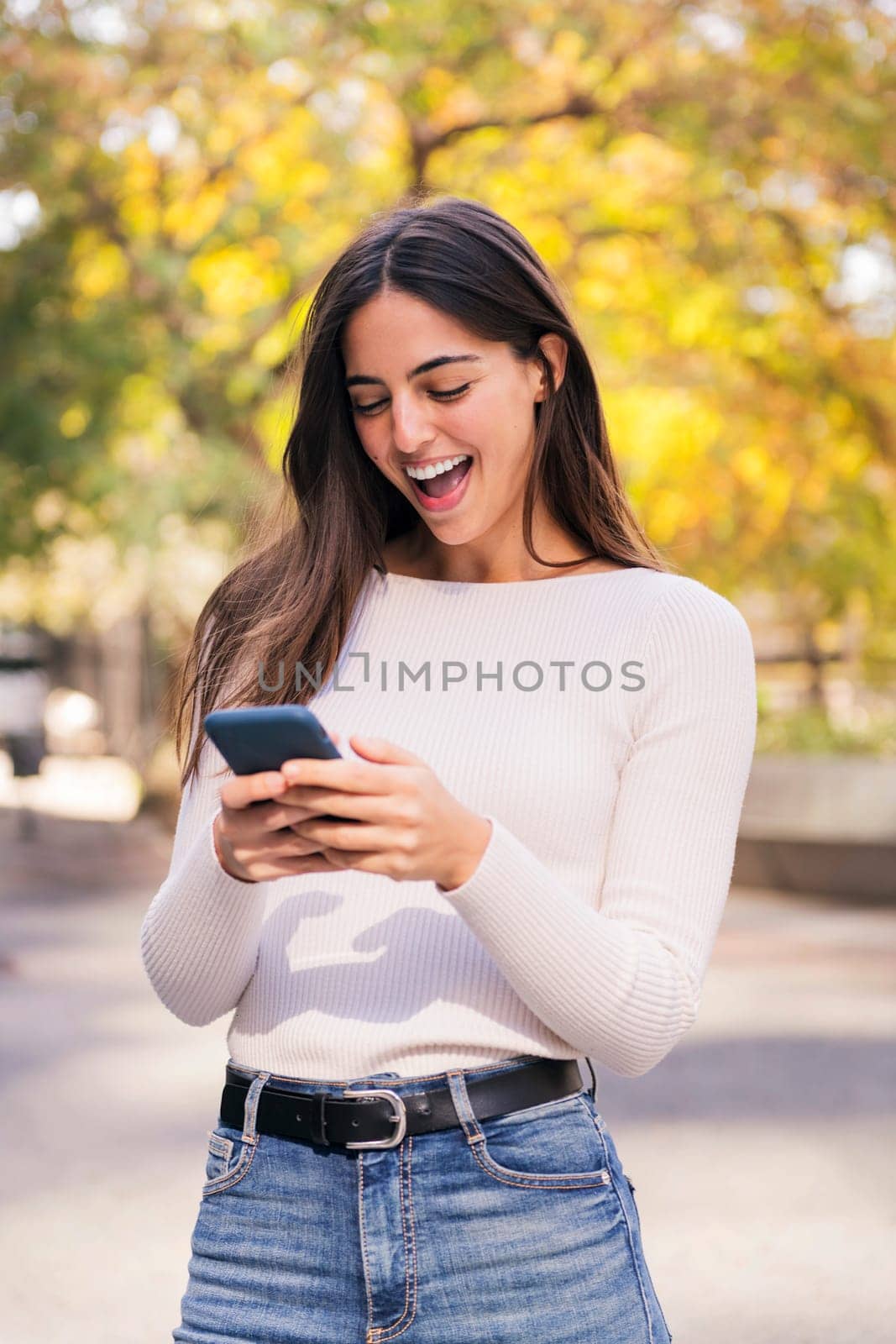 caucasian woman laughing happy using her mobile phone, concept of technology of communication and modern lifestyle