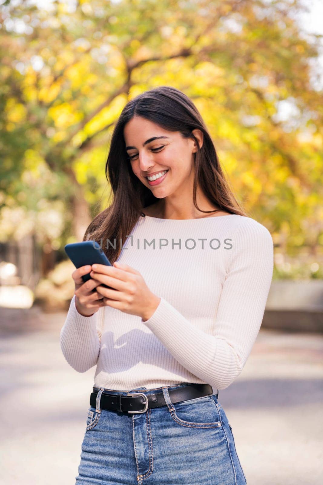 brunette woman smiling happy using her mobile phone, concept of technology of communication and modern lifestyle