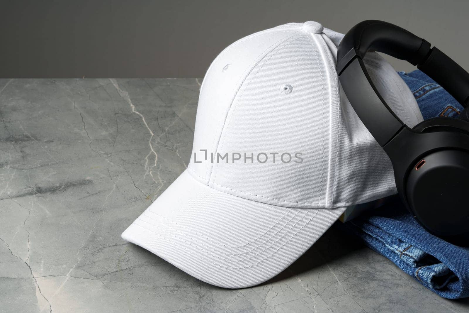 Baseball cap with black headphones on dark background studio shot