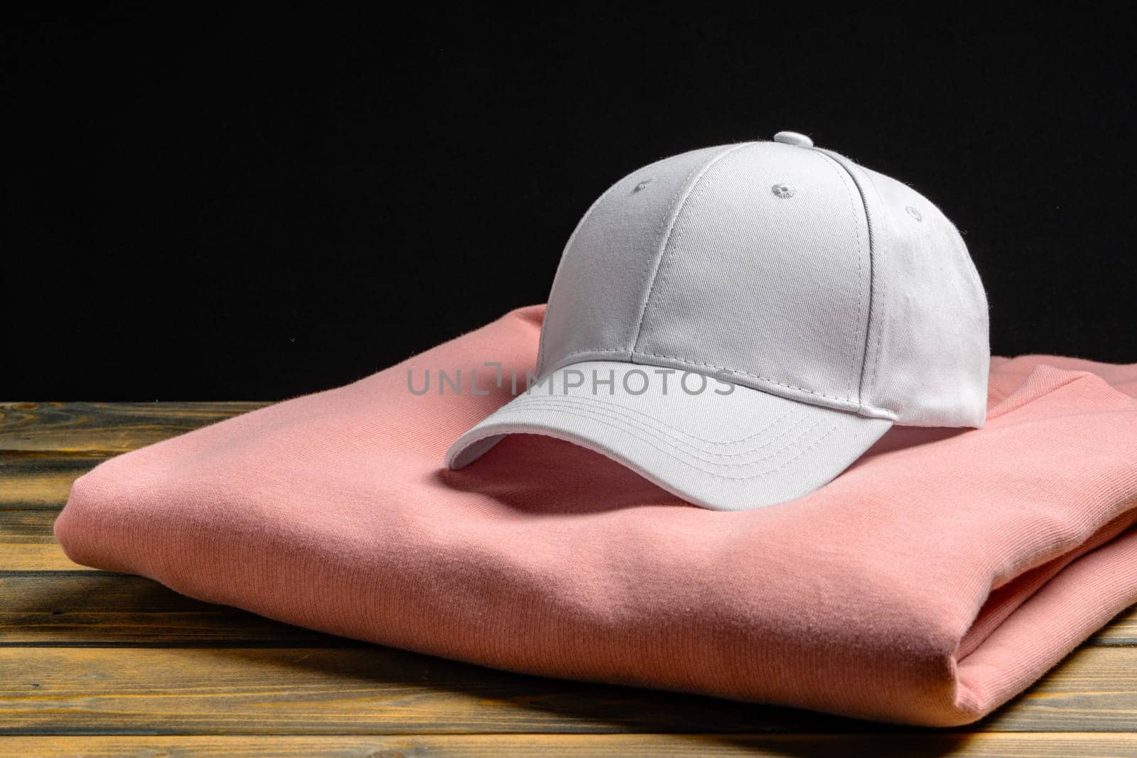 Trainers and baseball cap on wooden background close up