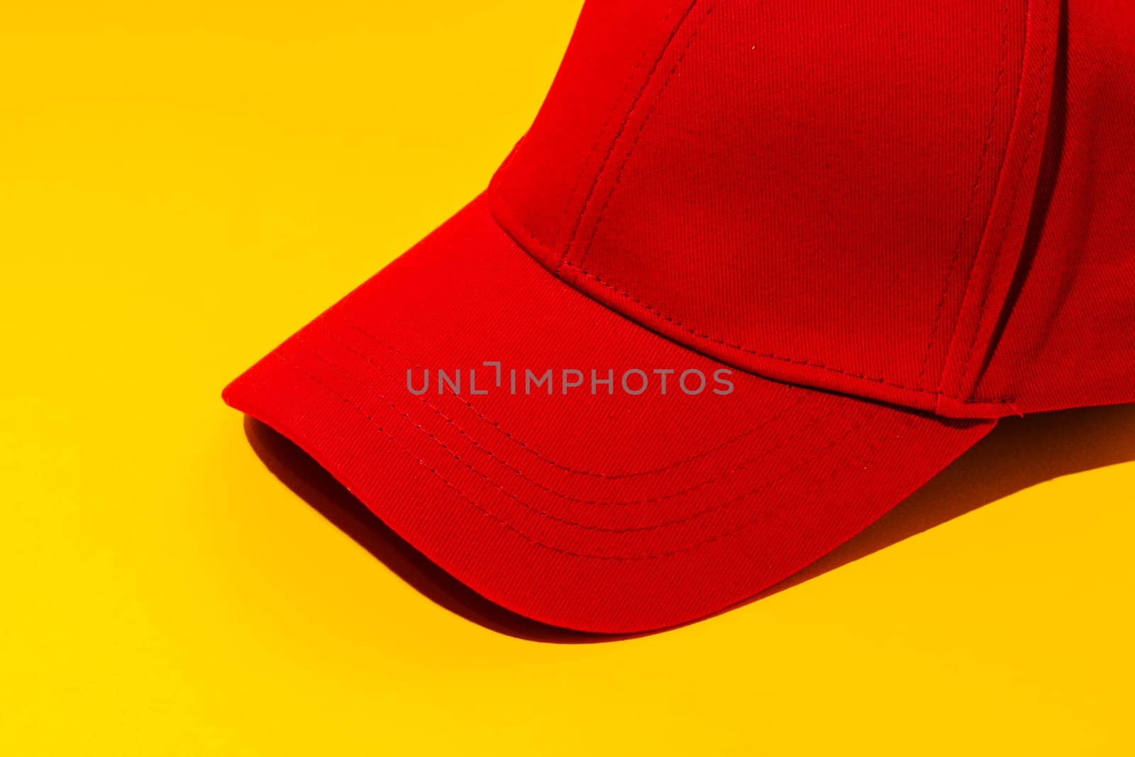Baseball hat against yellow background in studio by Fabrikasimf