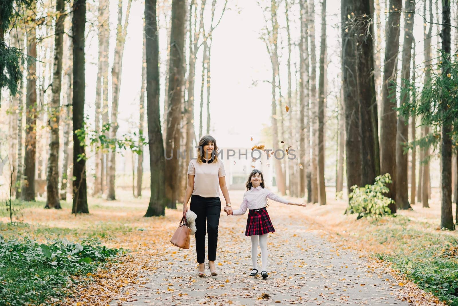 happy mother and daughter walking in the Park in autumn