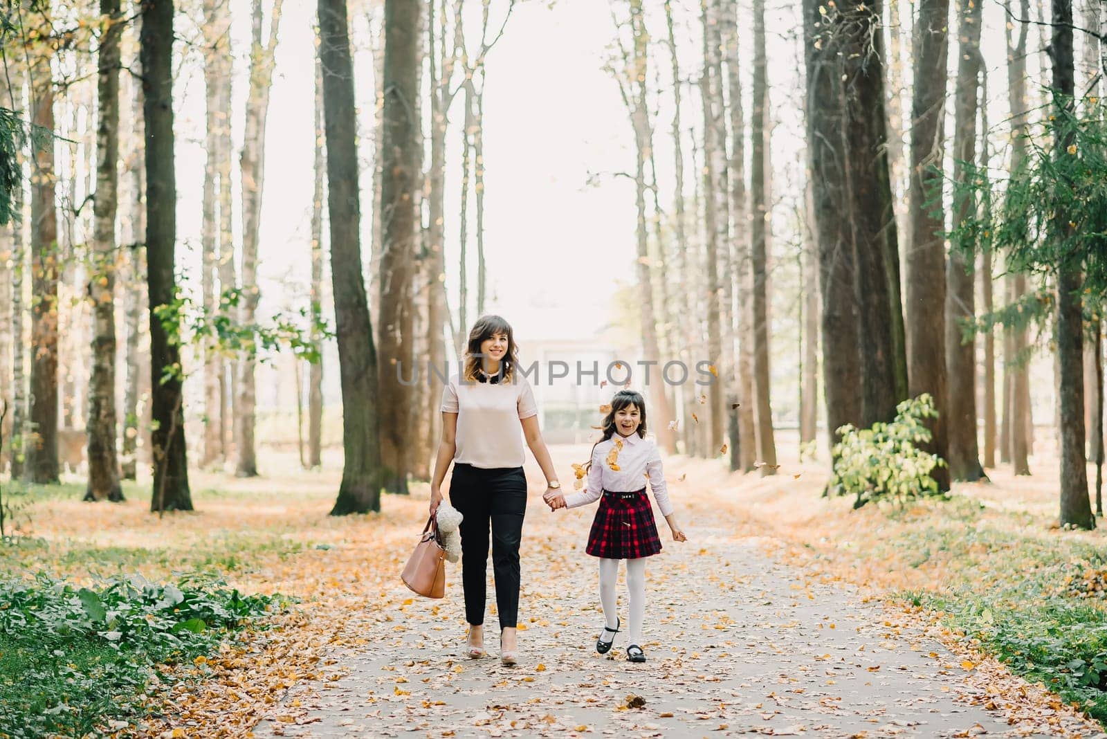 happy mother and daughter walking in the Park in autumn