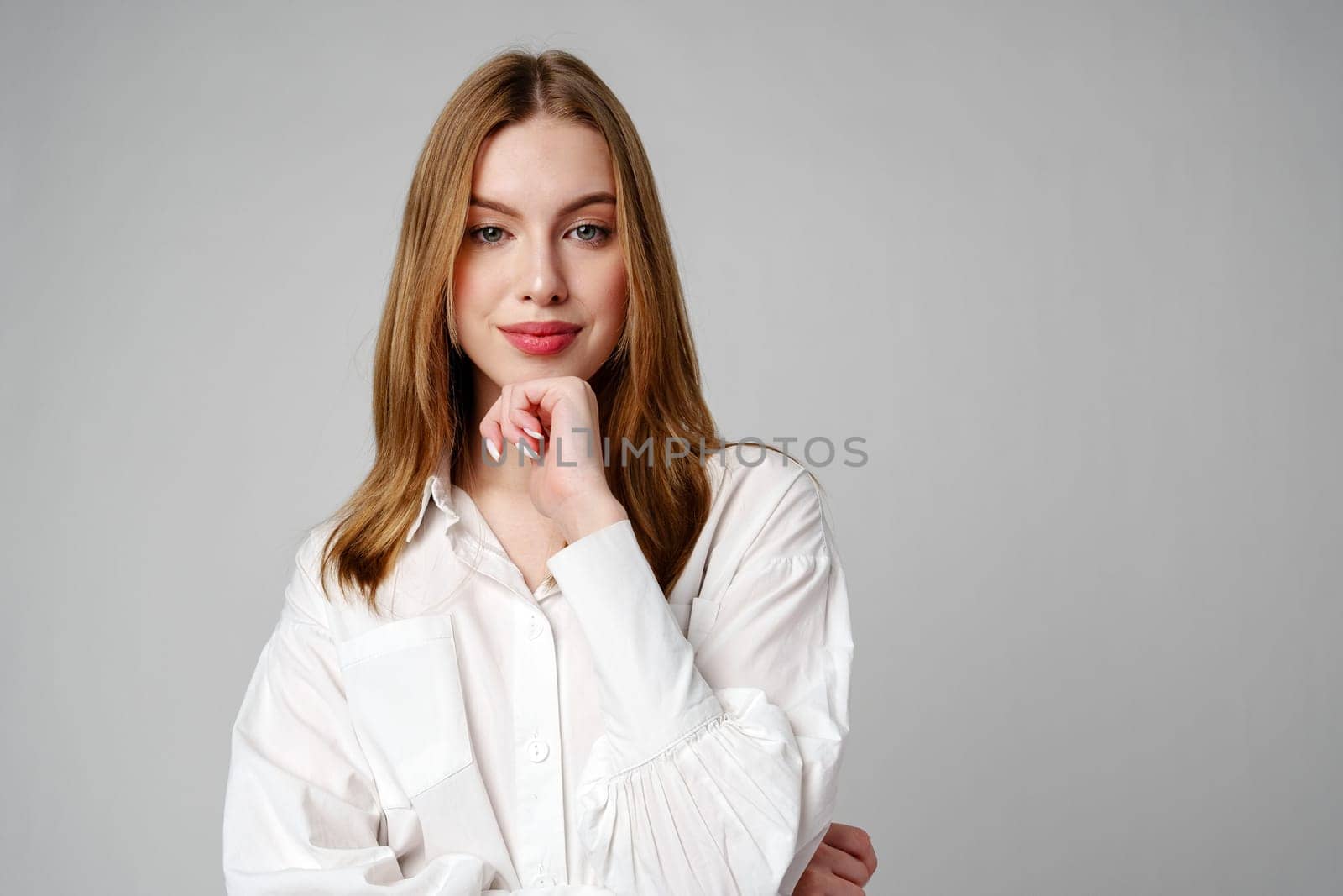 Joyful Young Blonde Woman Smiling against gray background by Fabrikasimf