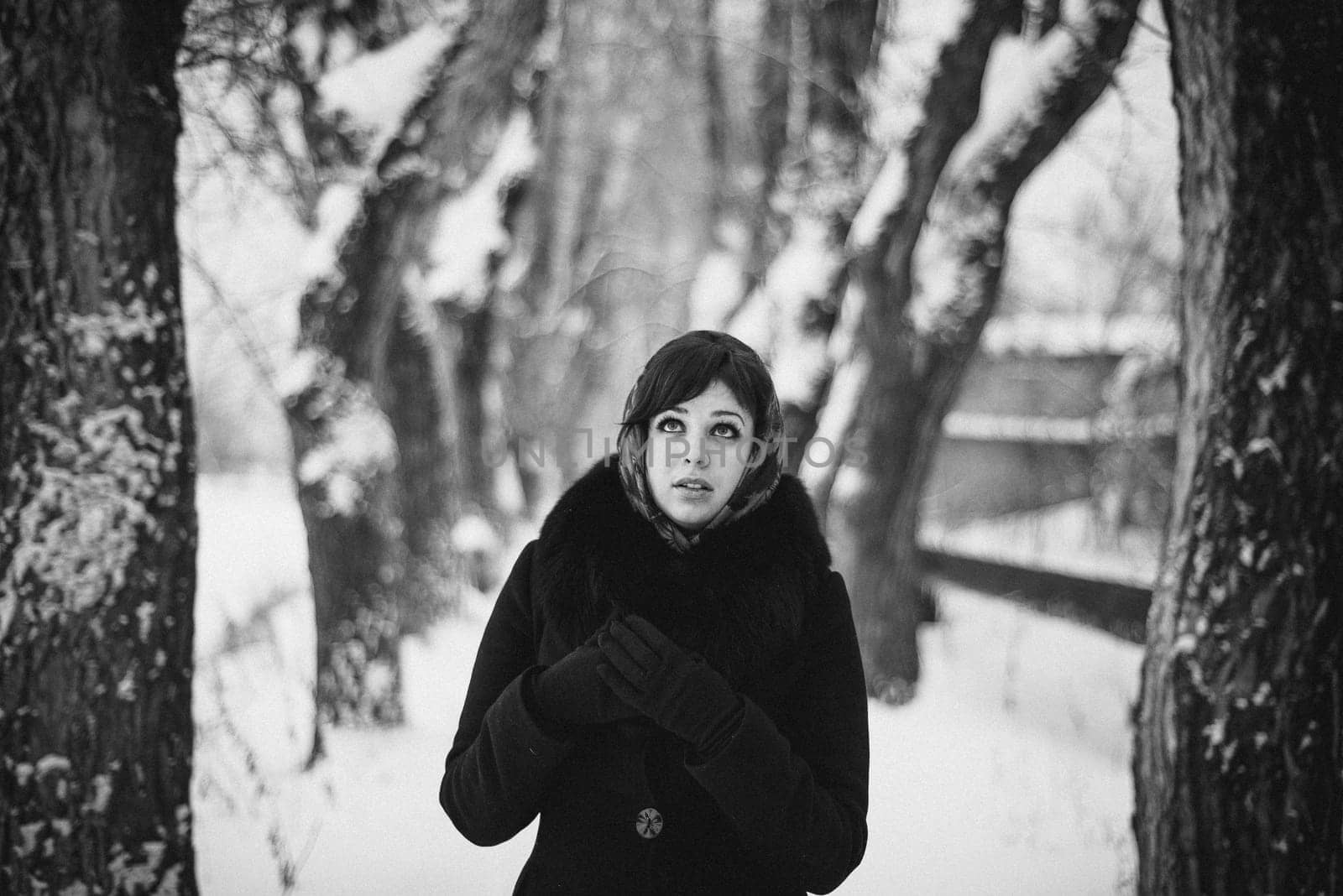 black and white portrait of a girl in a shawl in the winter in the woods