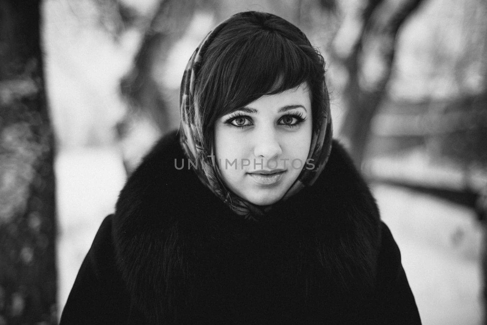 black and white portrait of a girl in a shawl in the winter in the woods
