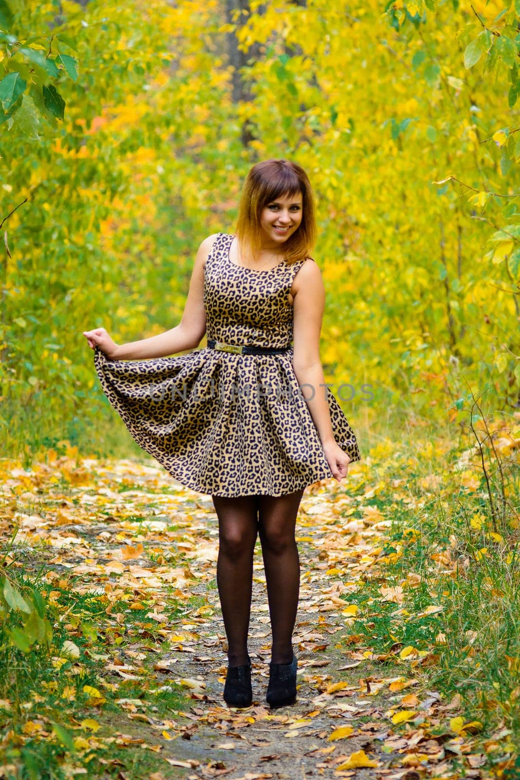 girl in dress and heels posing in autumn in the woods