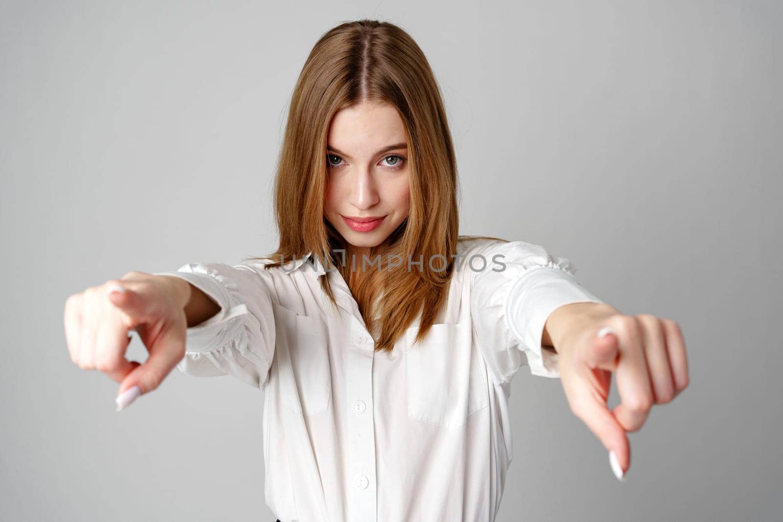 Young Woman in White Shirt Gesturing Come Here With Both Hands by Fabrikasimf