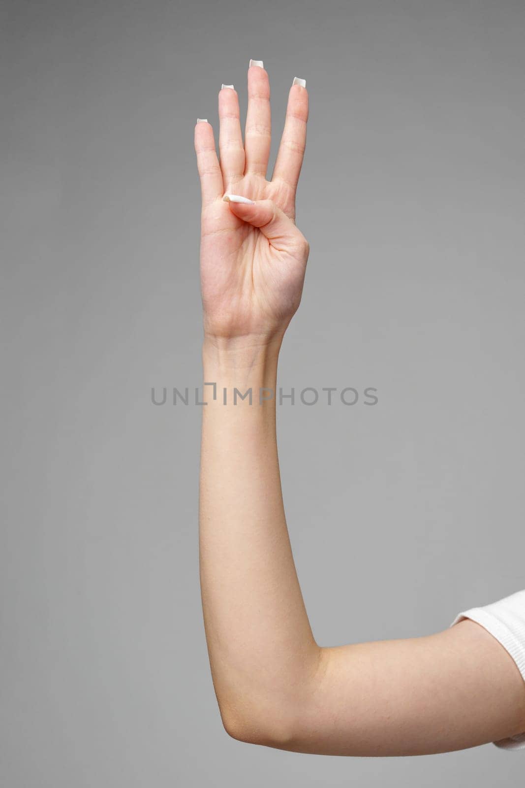 Female hand gesturing sign against gray background by Fabrikasimf