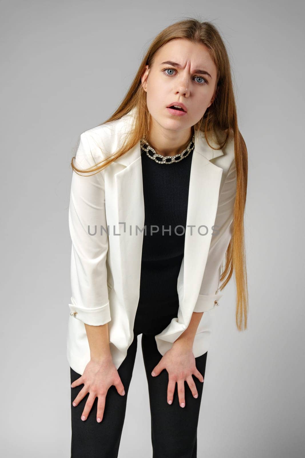 Young Woman Expressing Discontent against gray background by Fabrikasimf