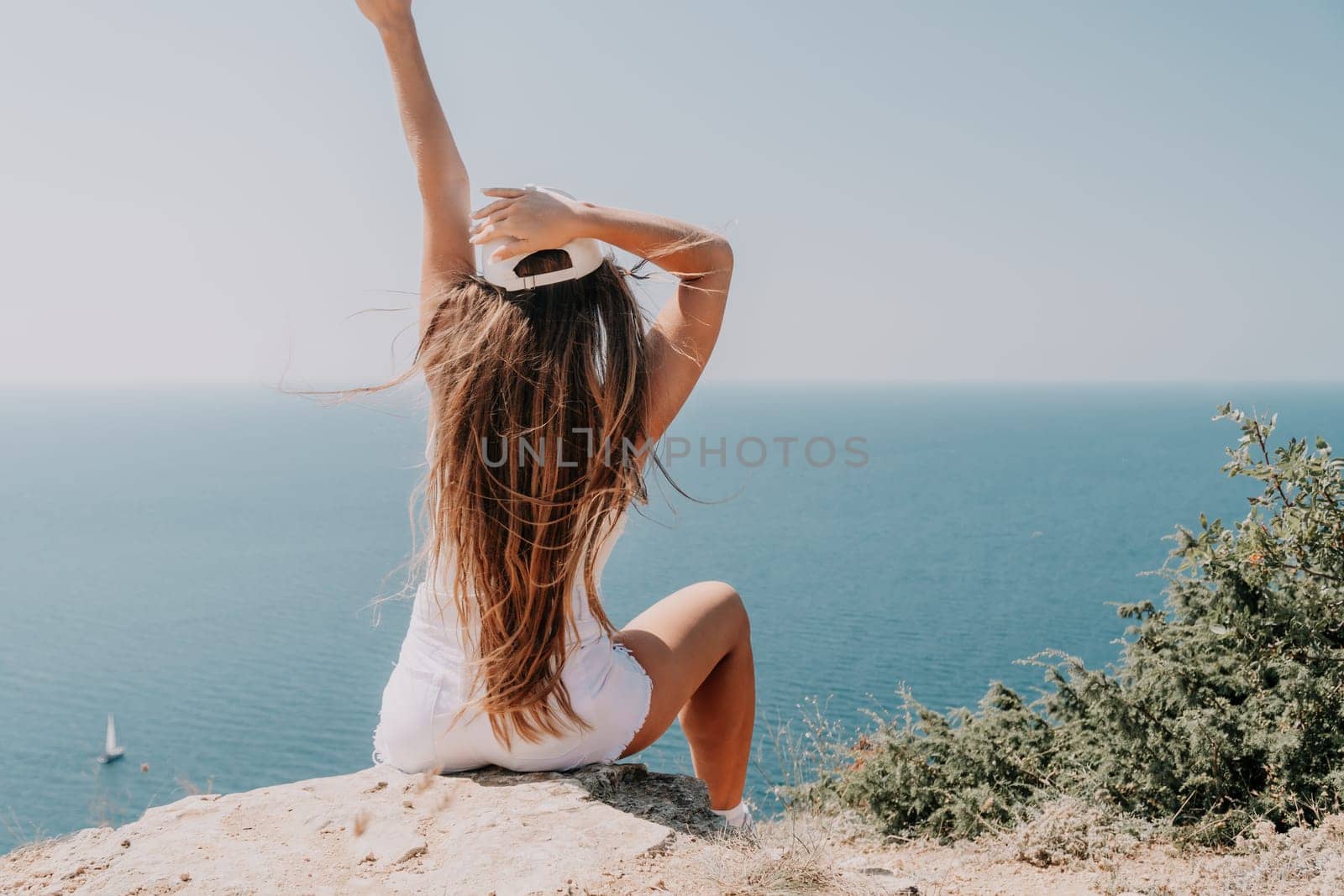 Woman summer travel sea. Happy tourist enjoy taking picture outdoors for memories. Woman traveler posing over sea bay surrounded by volcanic mountains, sharing travel adventure journey by panophotograph