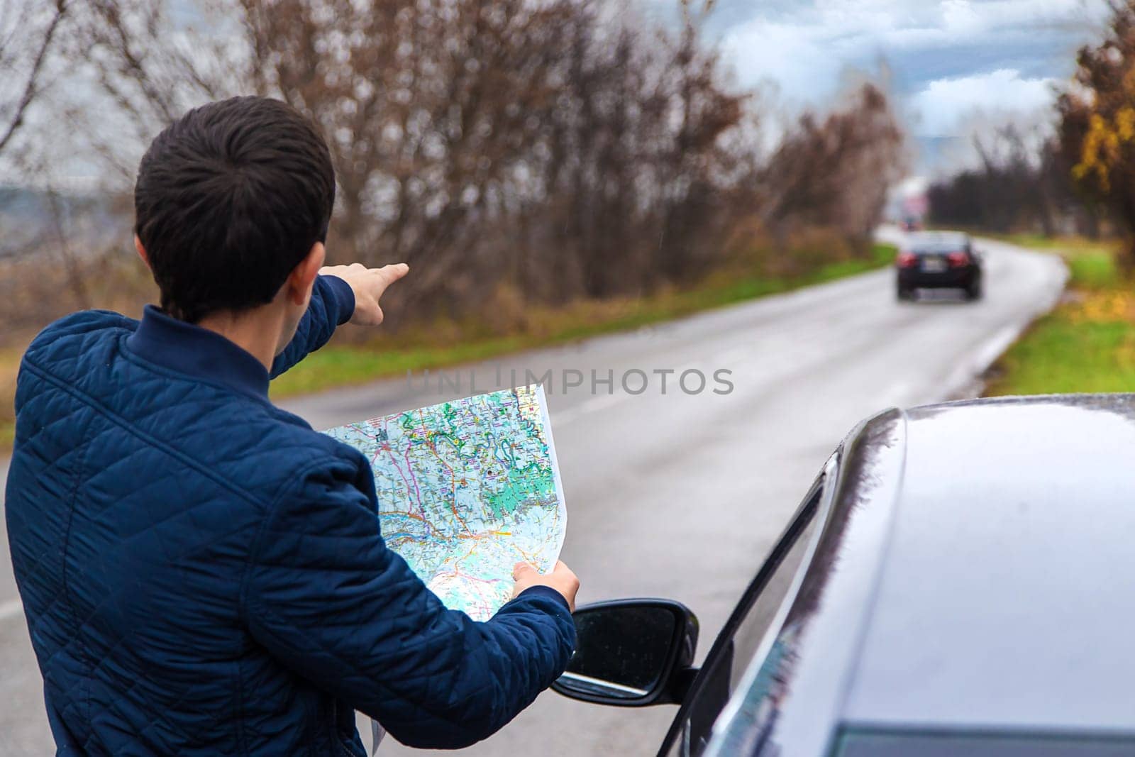 A man looks at a map on the road. Selective focus. People.