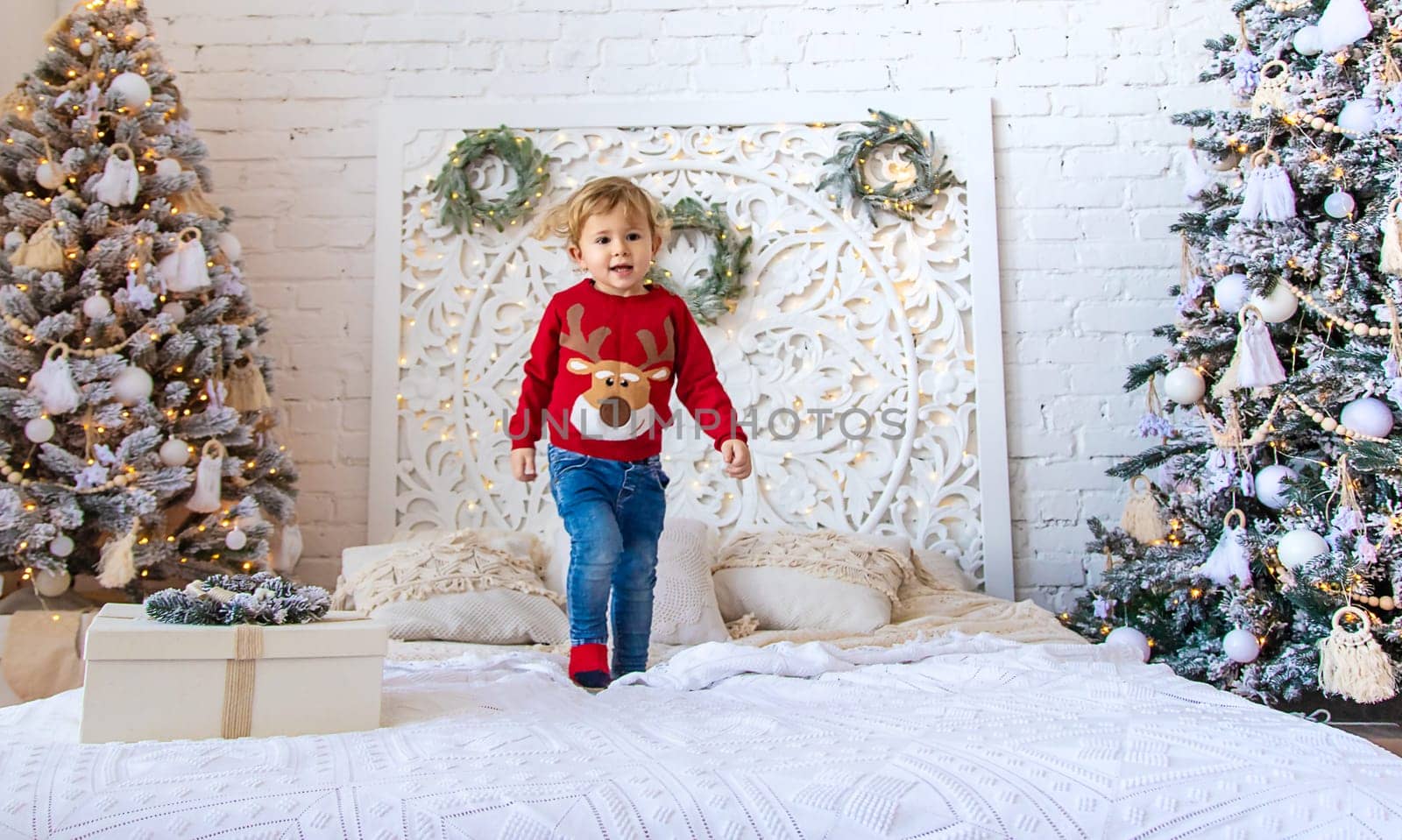 A child dances near a Christmas tree. Selective focus. Kid.