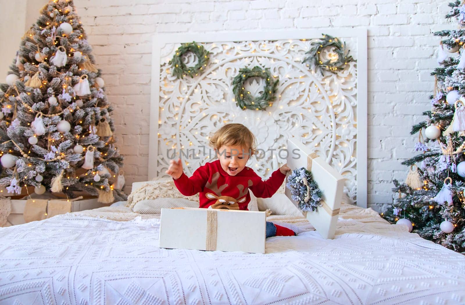 Child open Christmas gifts under the tree. Selective focus. Kid.