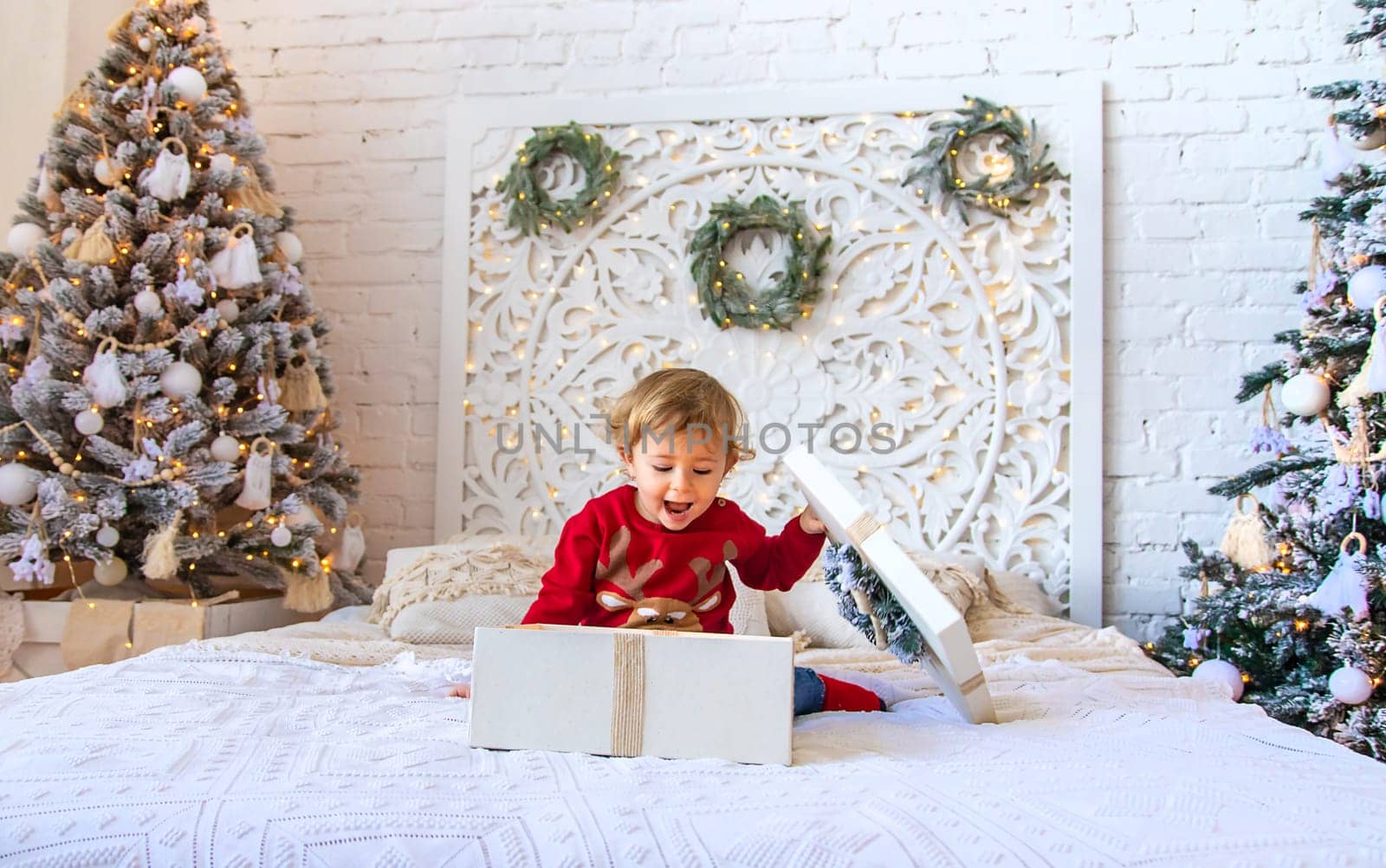 Child open Christmas gifts under the tree. Selective focus. Kid.