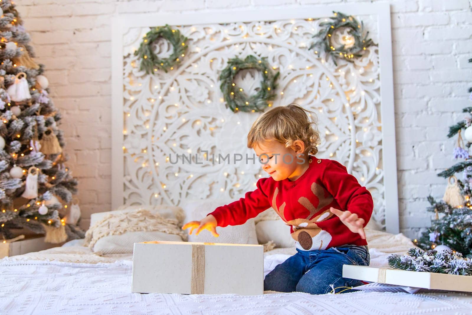 Child open Christmas gifts under the tree. Selective focus. Kid.