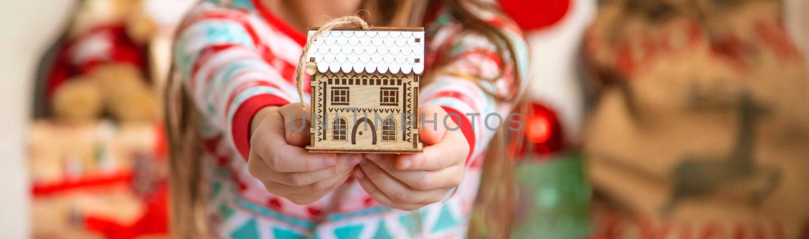 Christmas toy house child in hands. Selective focus. Kid.