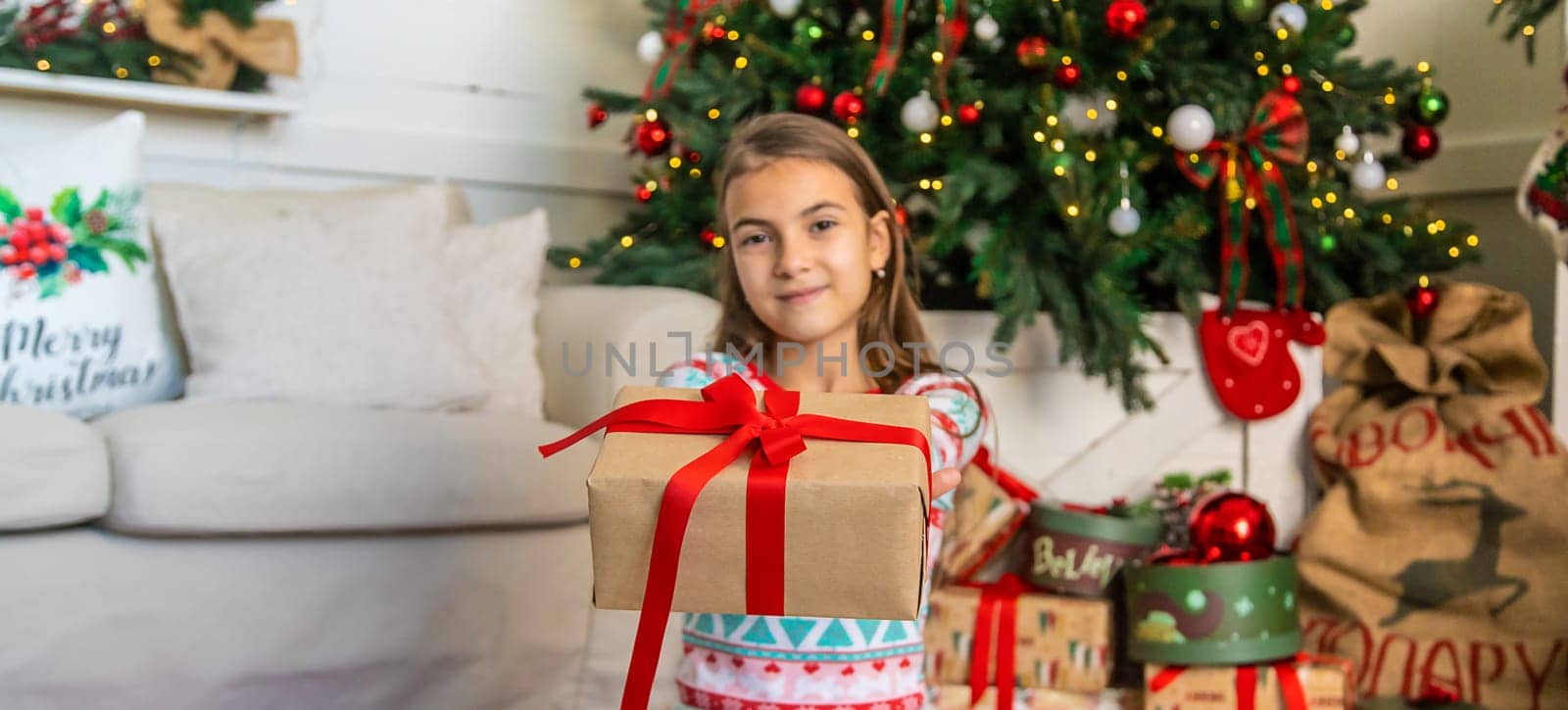 Children near the Christmas tree with a gift. Selective focus. Kid.