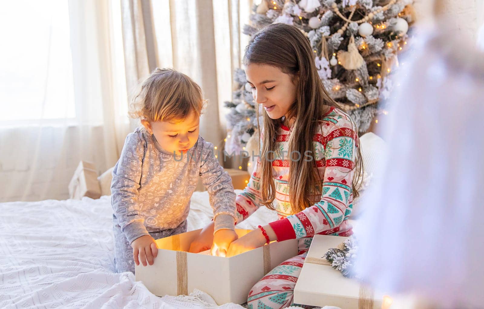 Child open Christmas gifts under the tree. Selective focus. Kid.