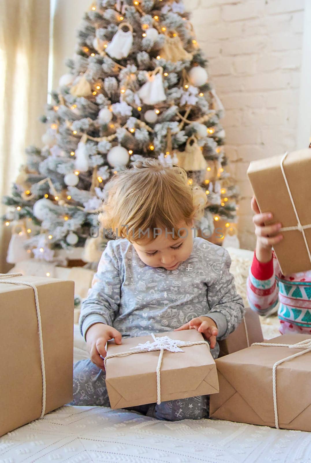 Child open Christmas gifts under the tree. Selective focus. Kid.