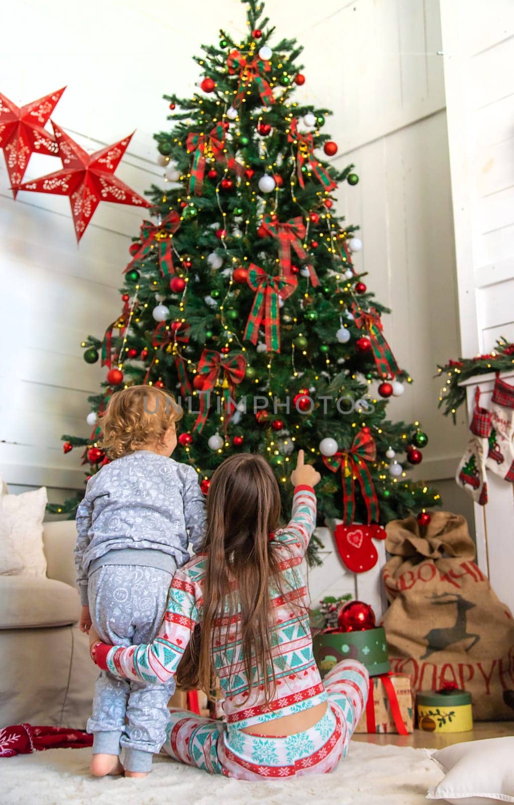 Children look at the Christmas tree. Selective focus. Kid.